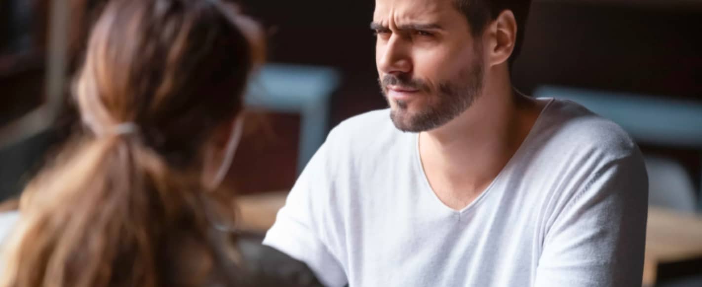 A man gives a confused look to the woman he's talking to.