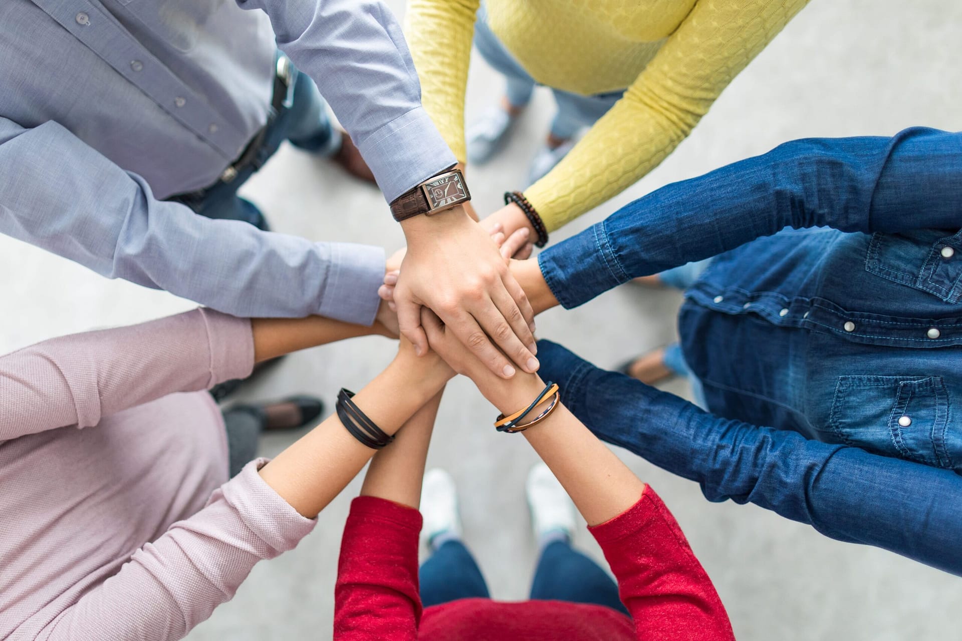 A group in a circle hands joined in the middle.