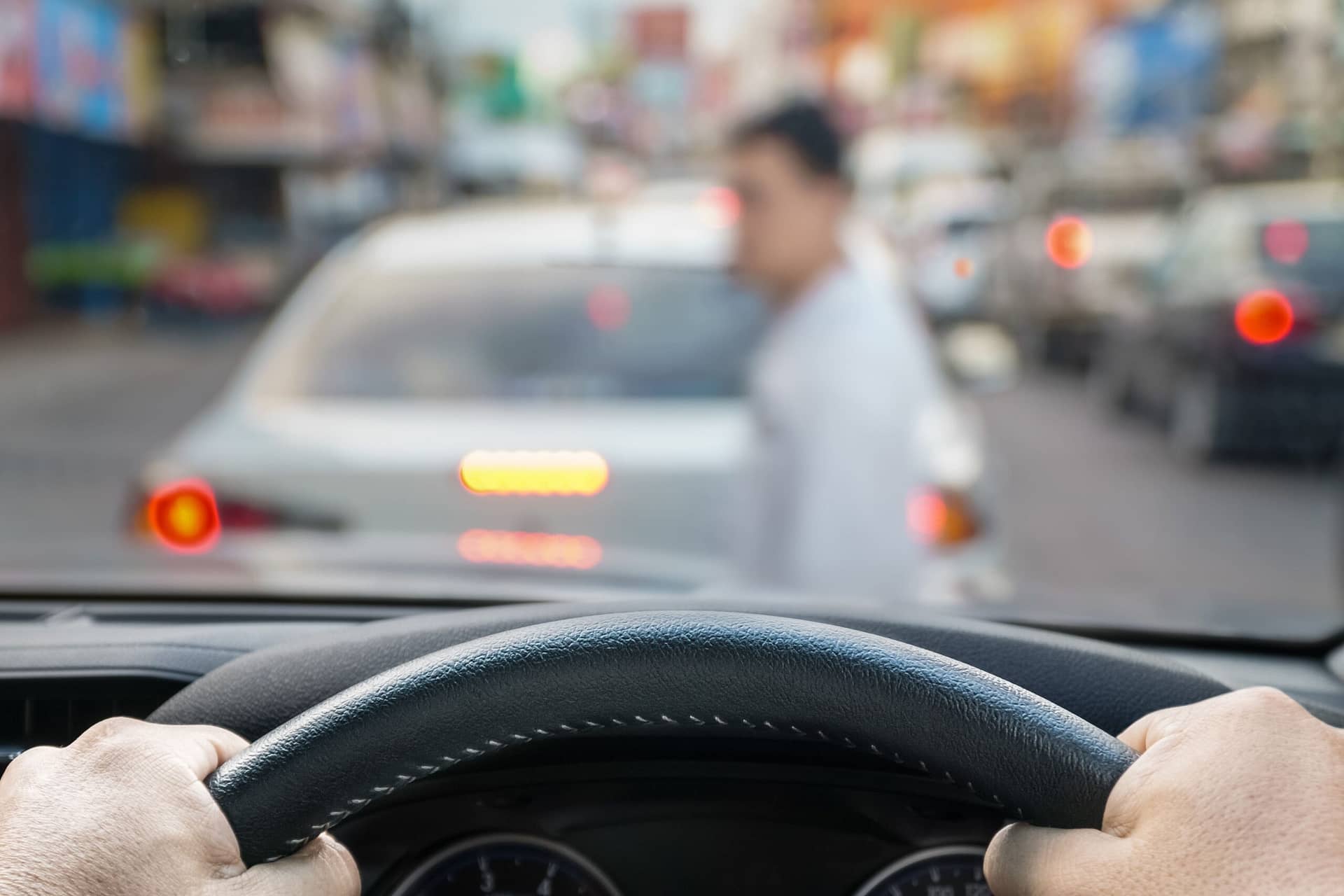 A driver grips the steering wheel, focused on the road.