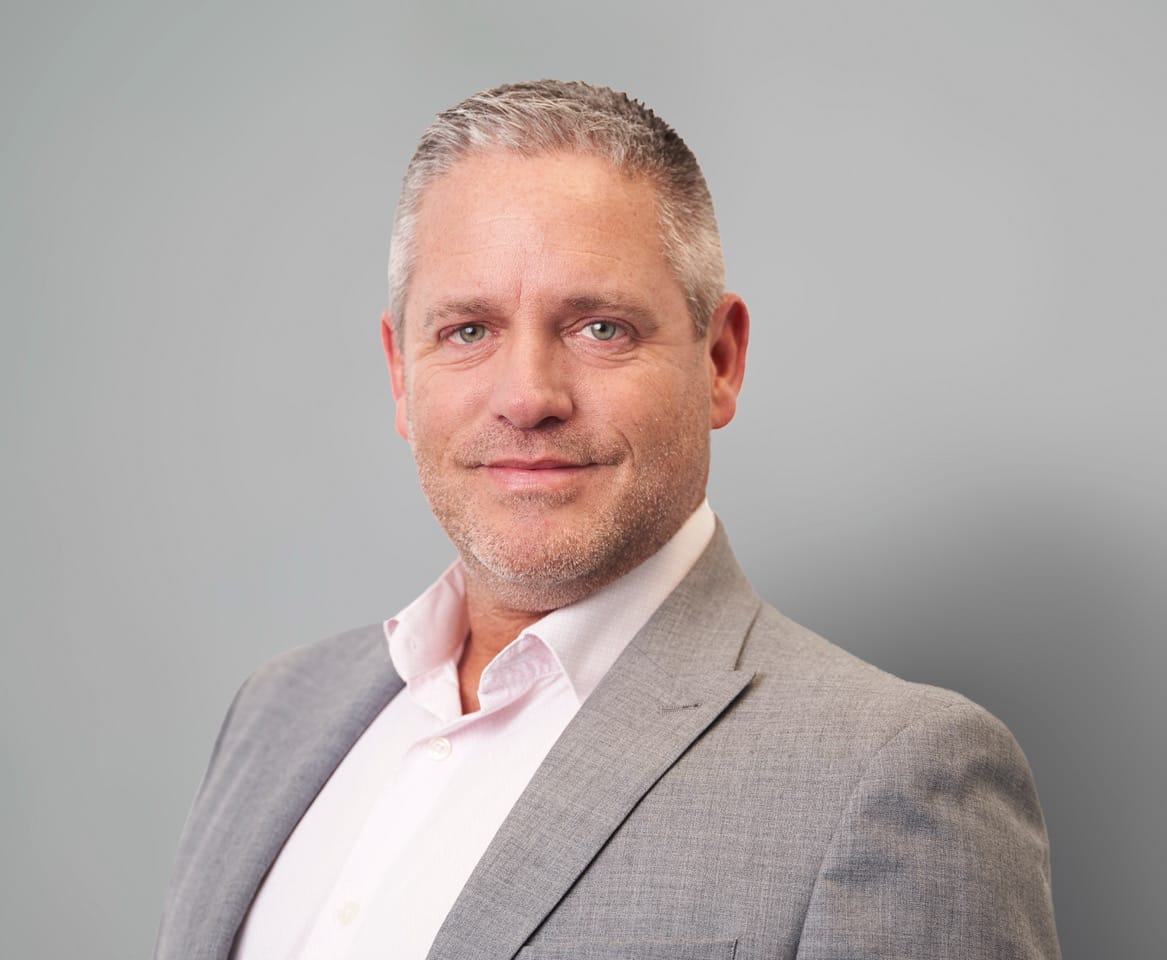 A man in a formal suit and white shirt, looking professional.