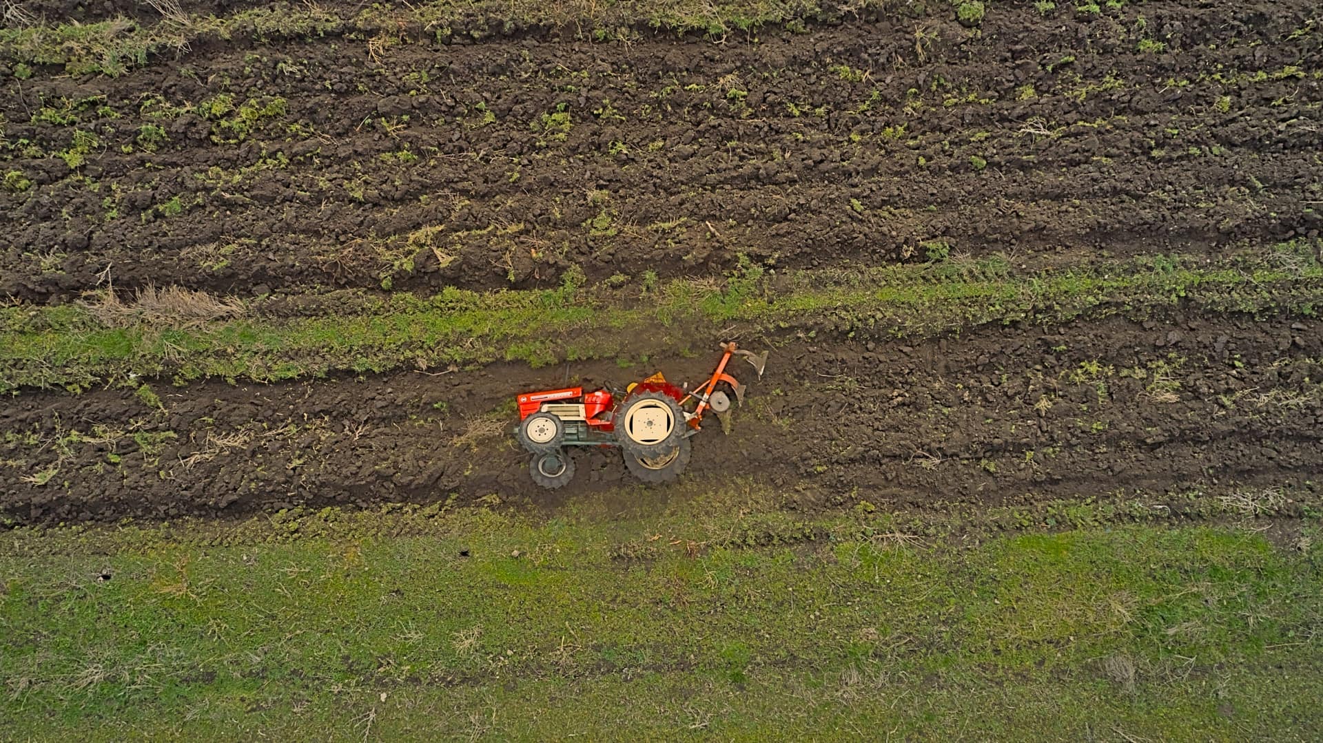 An overturned tractor in a field.