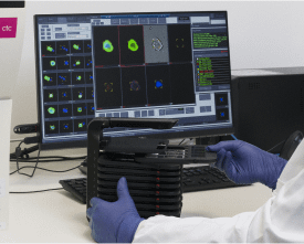 A man in a lab coat working on his computer.