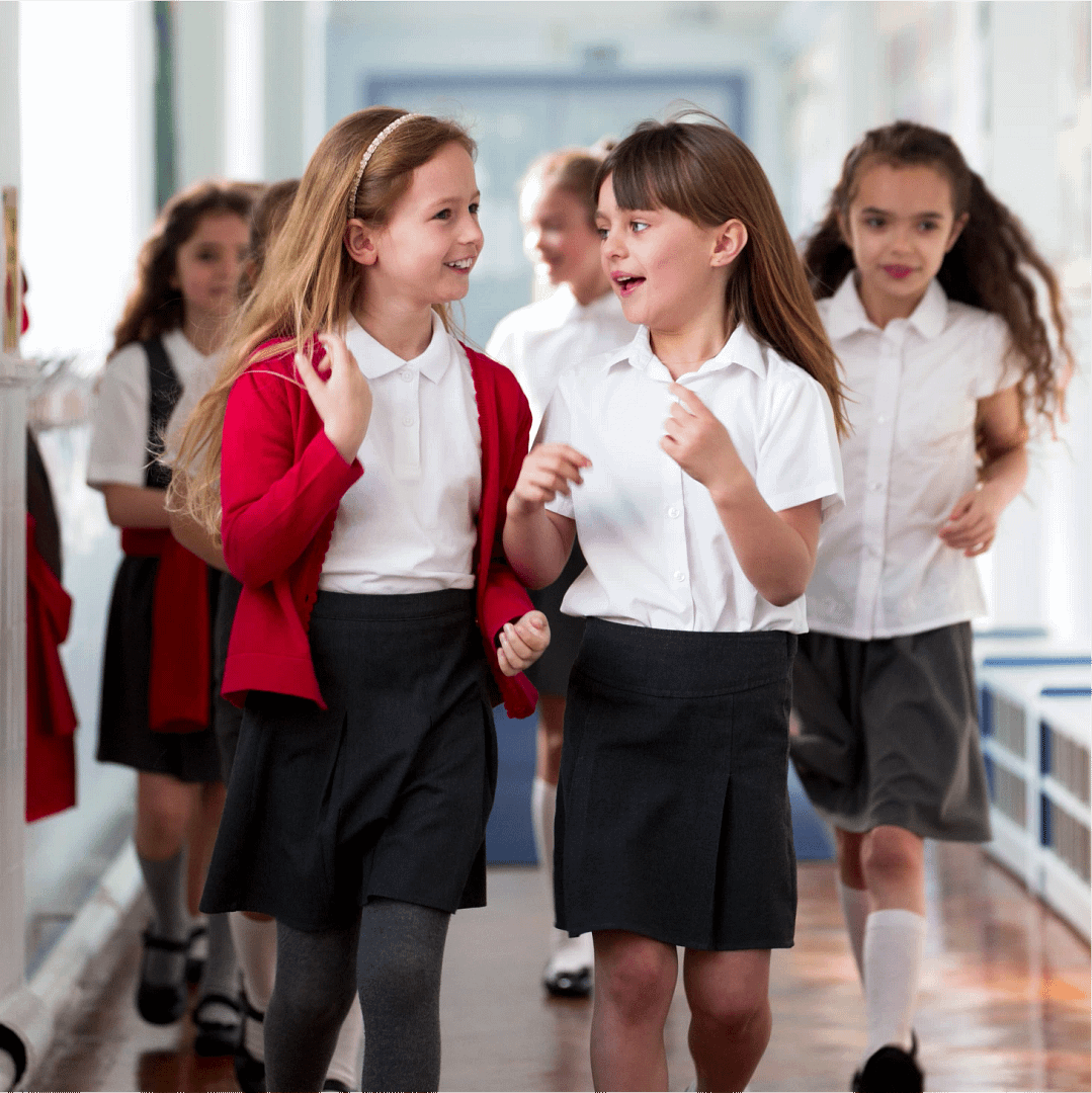 A group of primary school children walking and talking in a school corridor