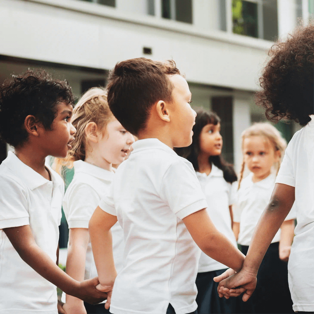 Group of school children holding hands in a circle
