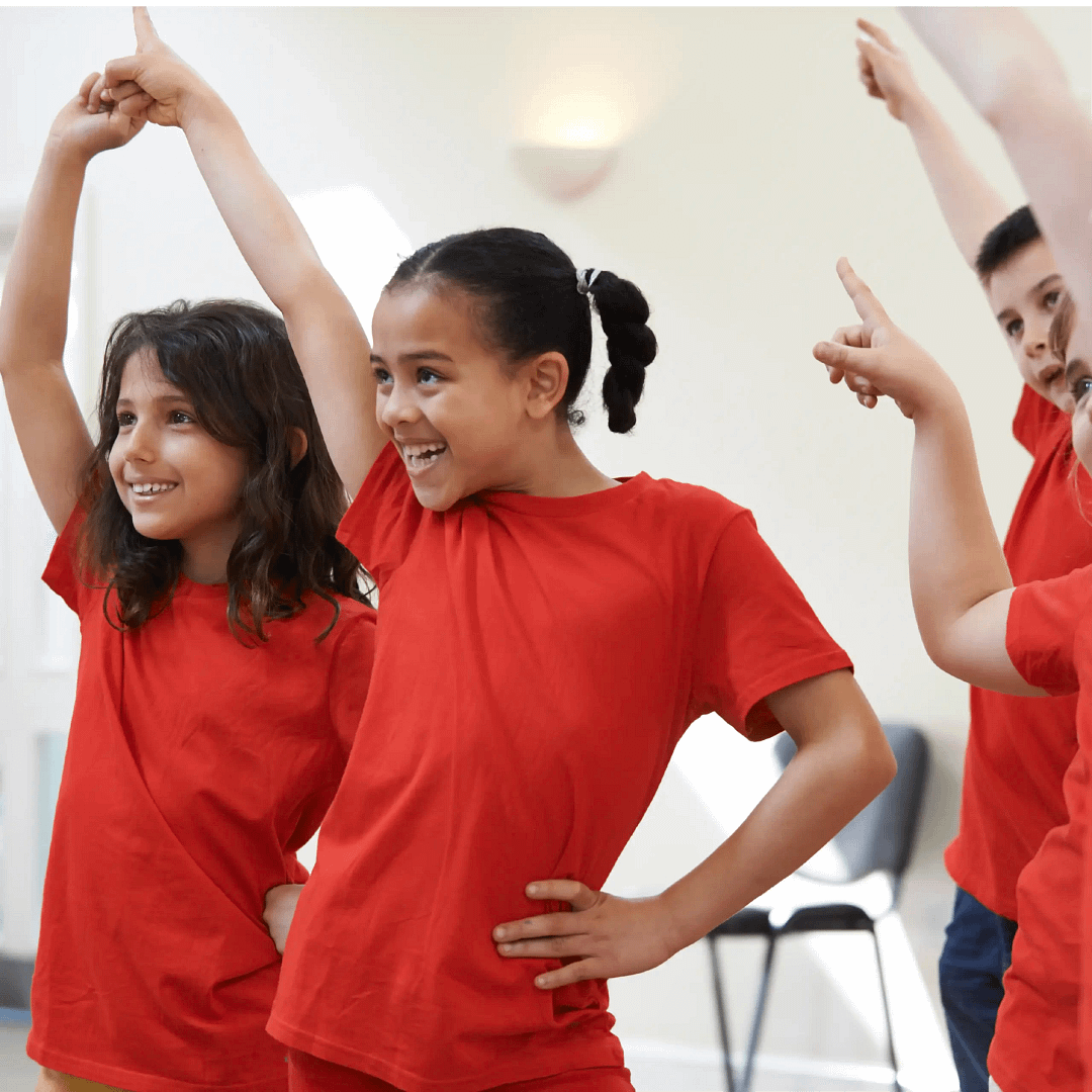 Children posing ready to start a dance with arms in the air