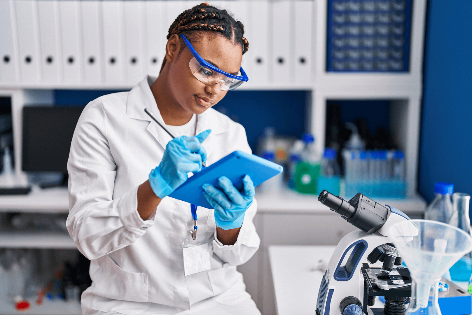 Woman in lab writing on tablet