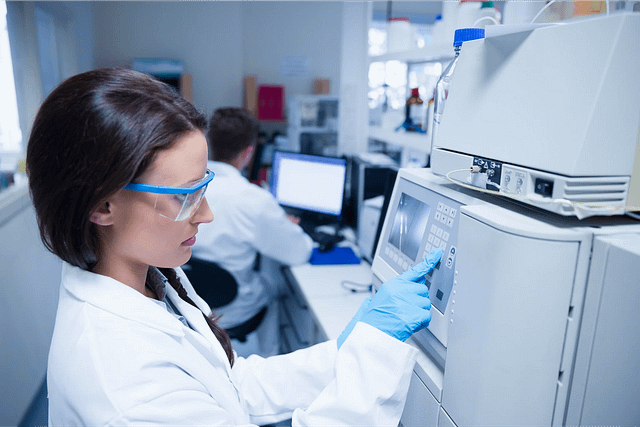 Female scientist working in a lab with a device