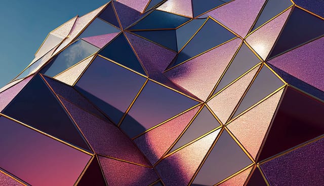 Close-up of a geometric facade featuring metallic purple and gold triangular panels reflecting sunlight.