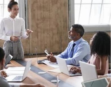 Woman talking to people by the desk in an office setting